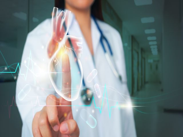 Ärztin in weißem Kittel berührt ein holografisches medizinisches Interface, das digitale Gesundheitstechnologien symbolisiert.
