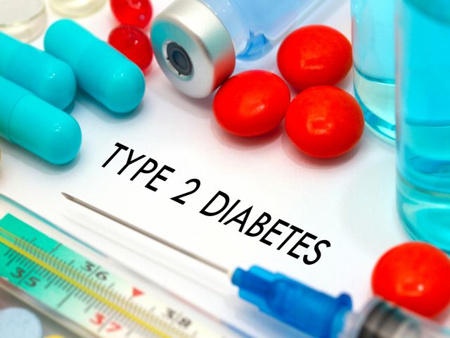 Medikamente und Spritzen zur Behandlung von Typ-2-Diabetes auf einem weißen Hintergrund.