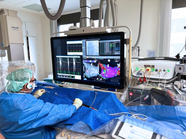 Herzkatheterlabor mit Monitoren und medizinischem Personal während einer Ablation.